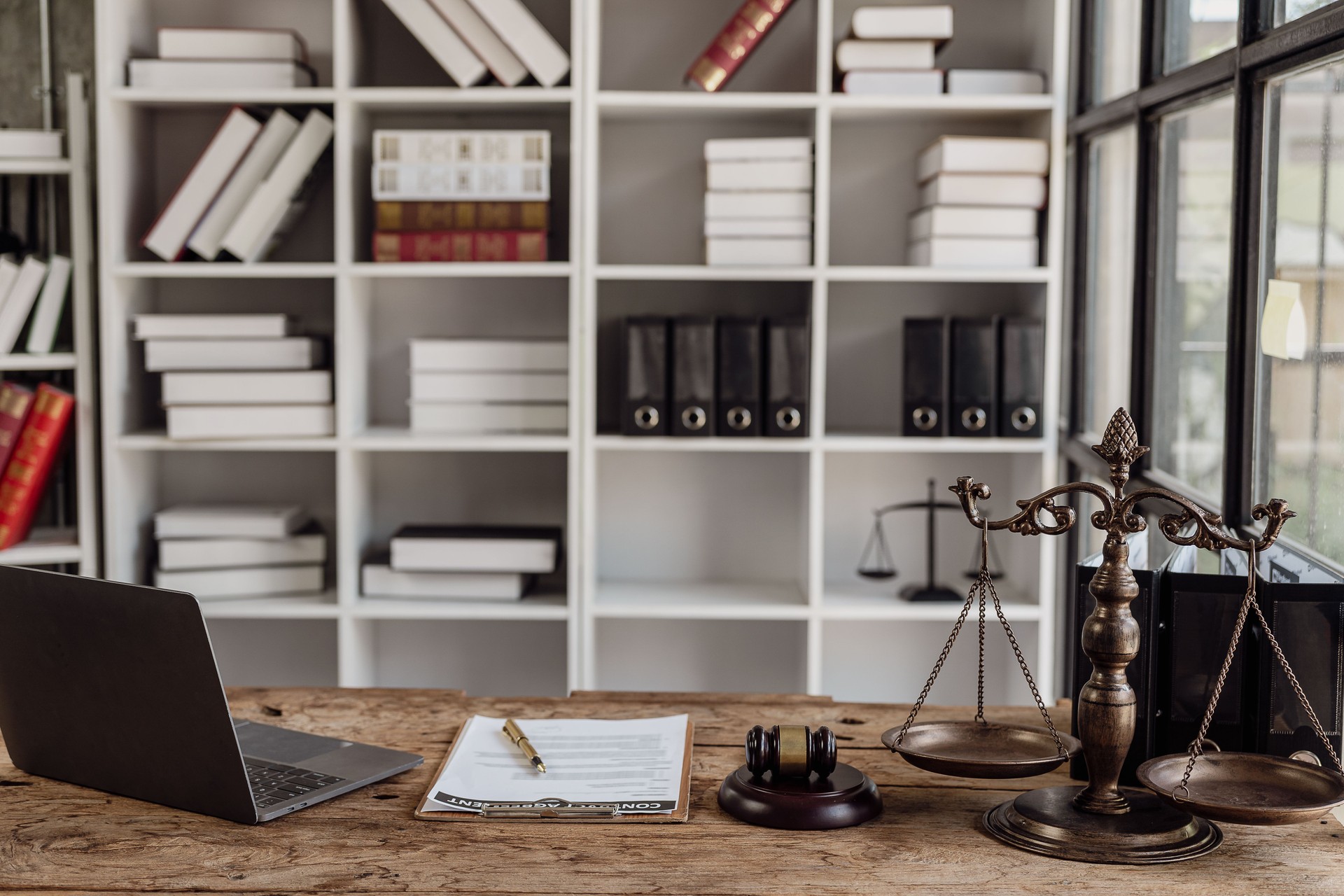 Judge's gavel, legal scales and books on black background. Legal concepts regarding judiciary and justice Justice concept at workplace of lawyer with laptop
