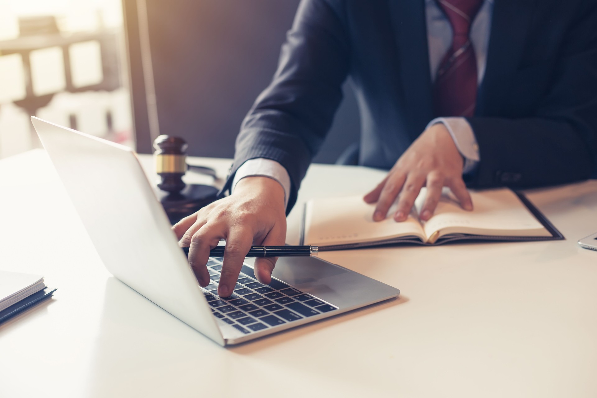 Abogado usando computadora portátil para información de litigios en bufetes de abogados.
