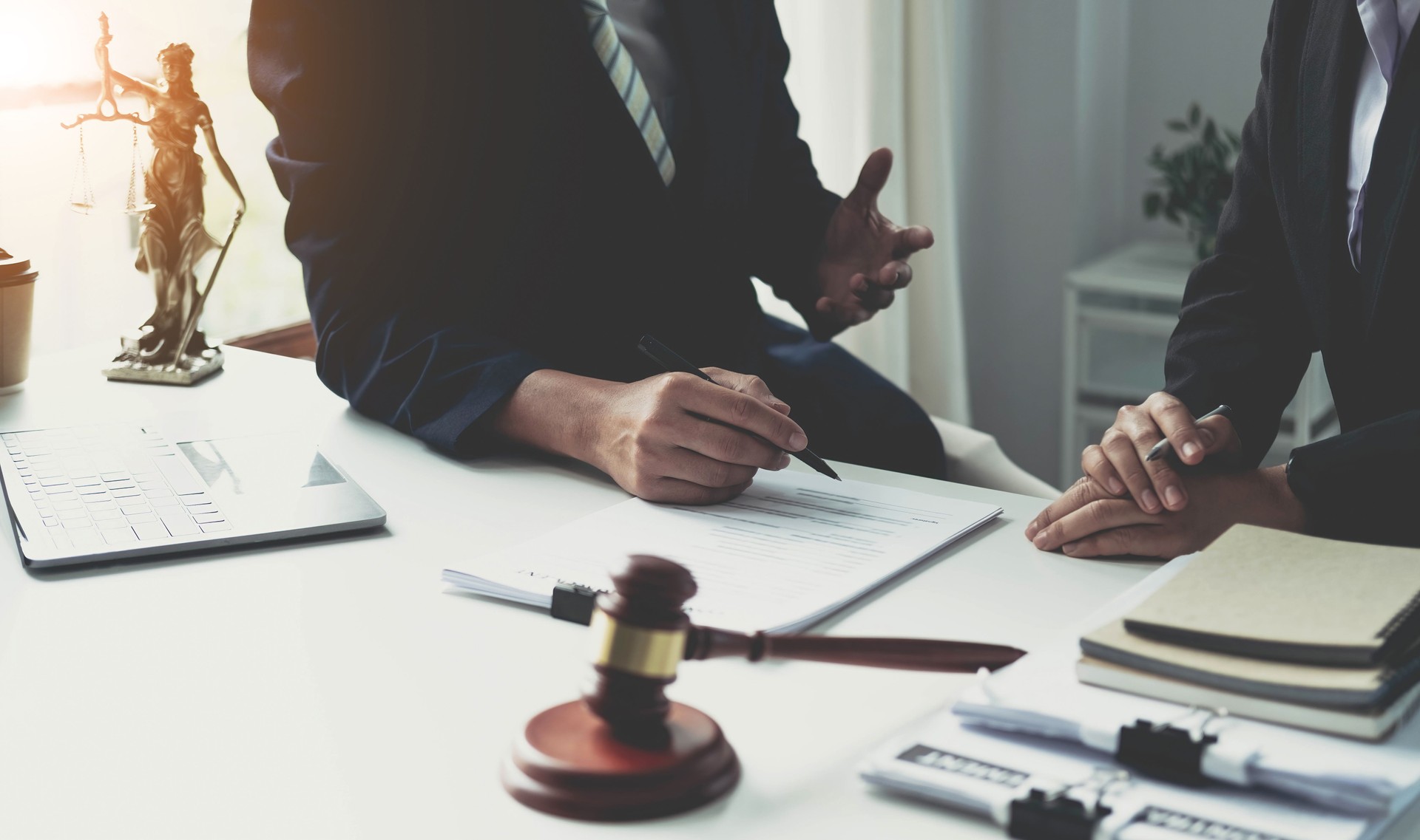 Consulta y conferencia de abogados varones y empresaria profesional que trabajan y discusión teniendo en el bufete de abogados en la oficina. Conceptos de derecho, juez gavel con escalas de justicia.
